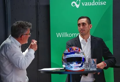 Sébastien Buemi in conversation beside his race helmet at a Vaudoise event
